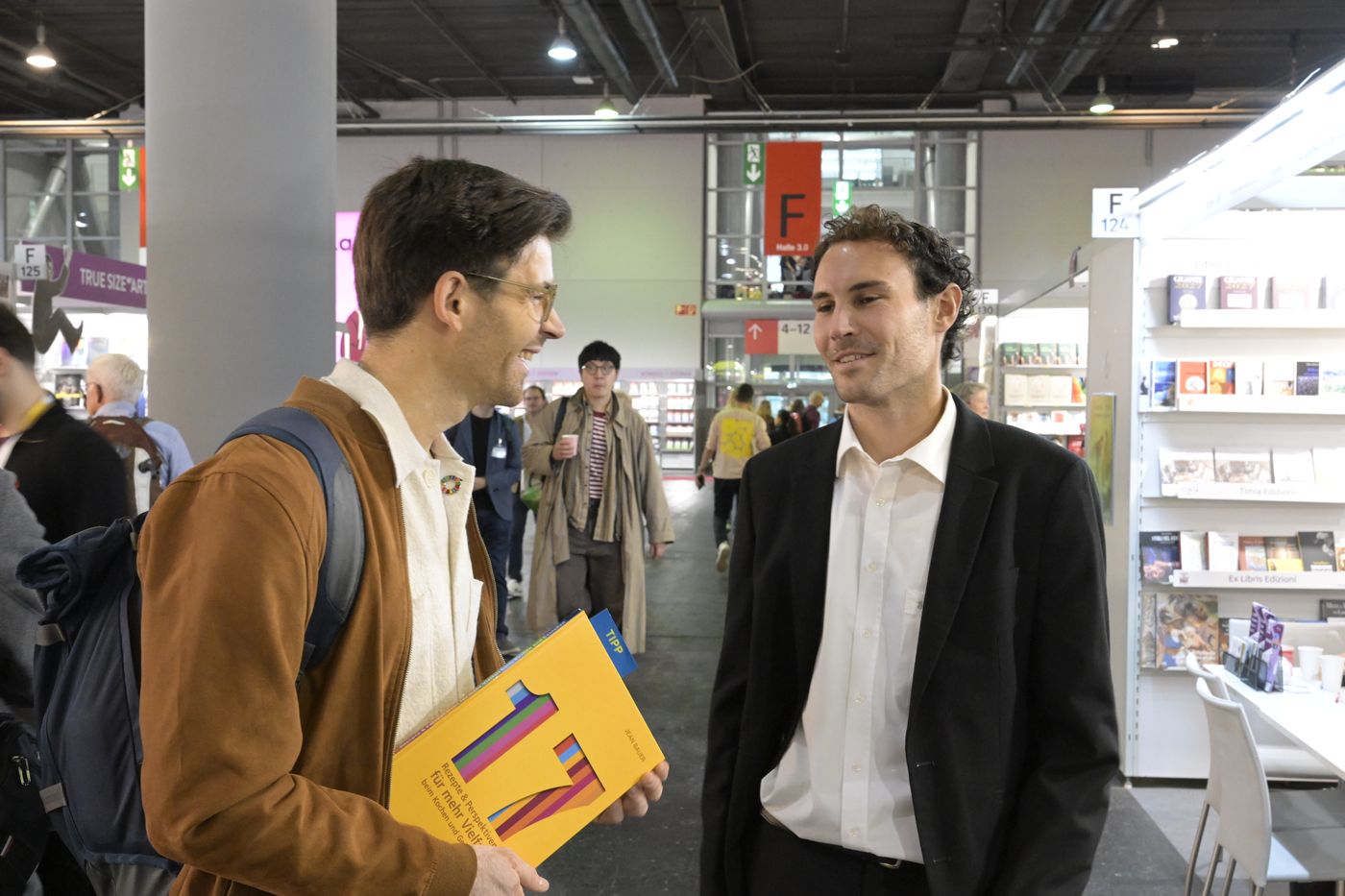 Jean Bauer im Gespräch auf der Buchmesse, das Buch „17“ in der Hand