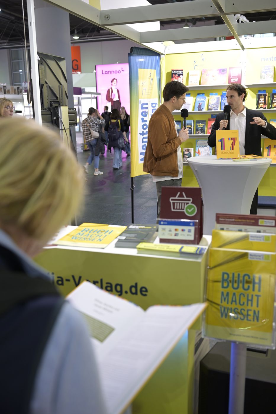 Besucherin blättert im Buch am Messestand